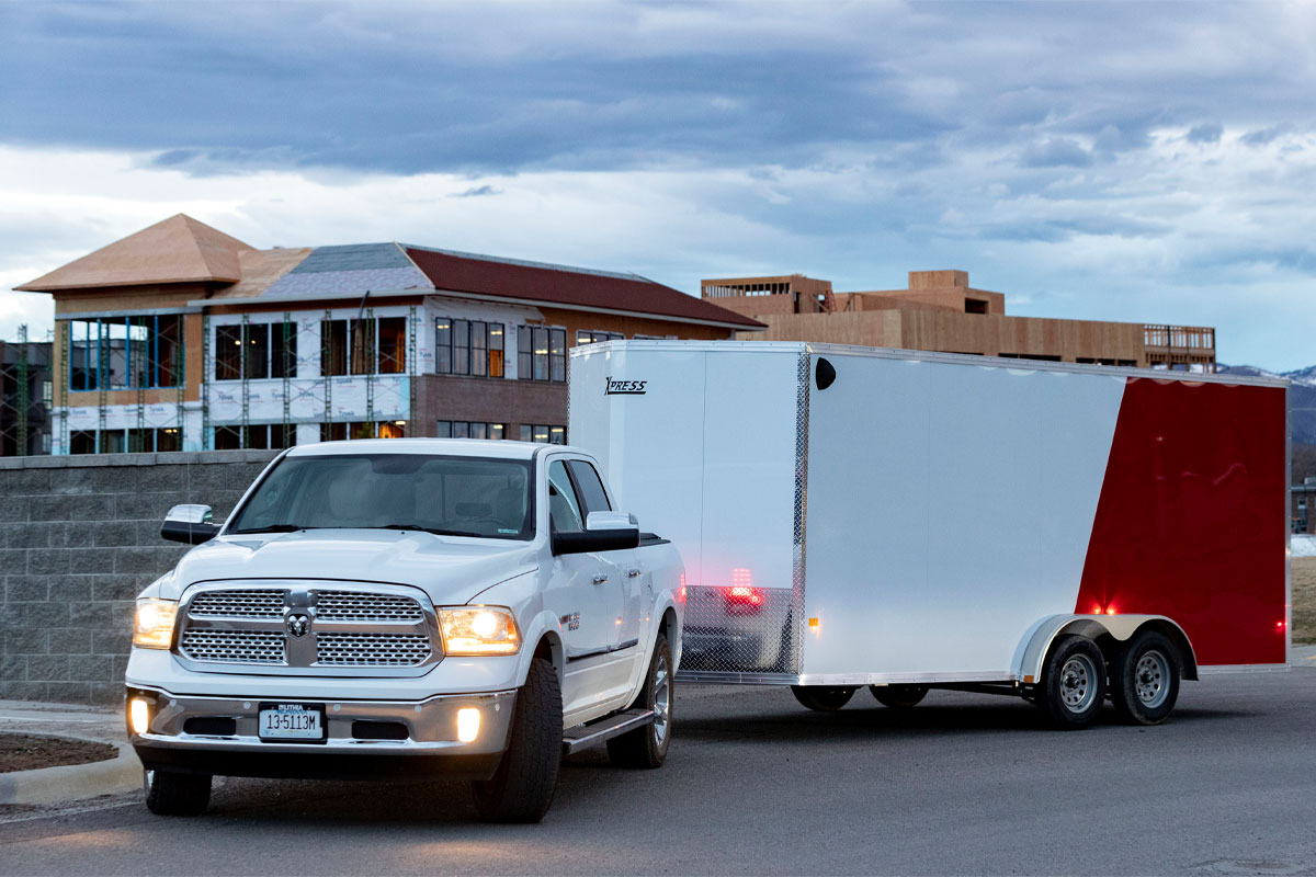 Front View Of White Truck Hauling Xpress White Enclosed Cargo 8.5 Wide Trailer